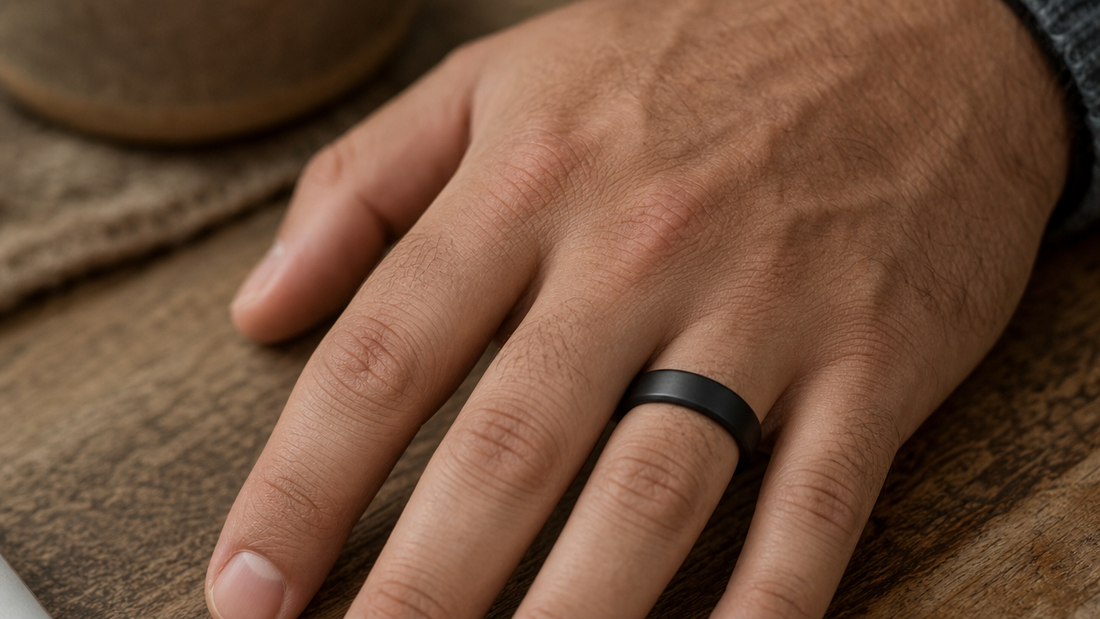 Man wearing a sleek, matte black wedding band on his finger, symbolizing modern commitment and personal style.