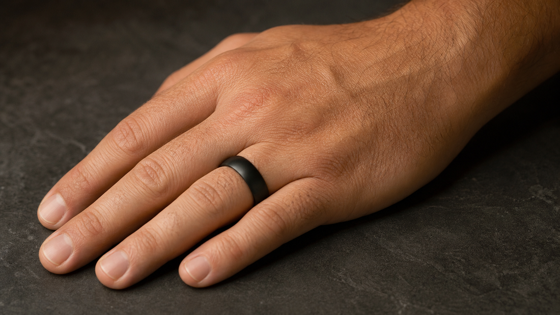 Man wearing a sleek matte black black wedding band on his finger, symbolizing modern commitment.