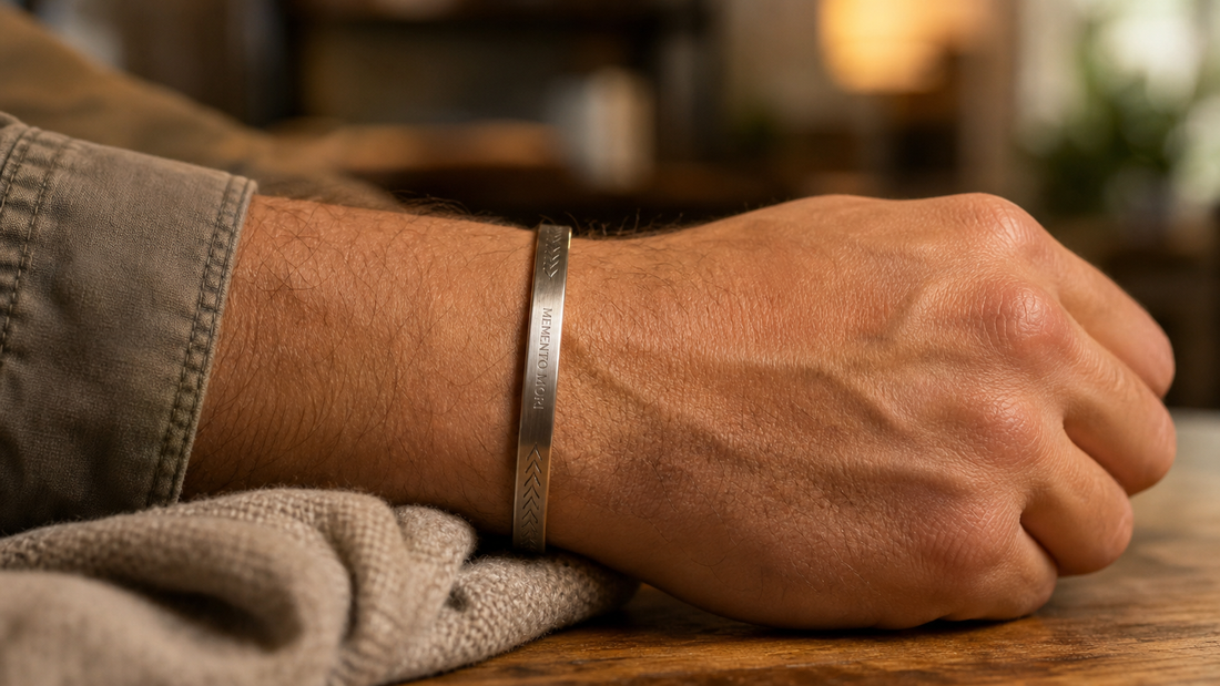Close-up of a man wearing a subtly engraved metal bracelet, symbolizing personal connection and sentiment.