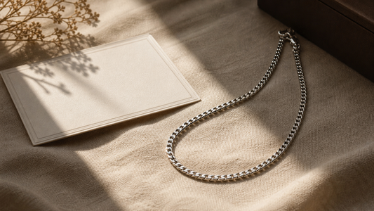Sleek silver men's chain necklace with a heartfelt message card on a warm, textured background