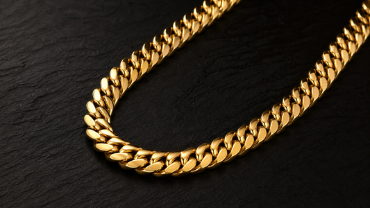 A close-up of a polished gold Cuban link chain for men, showcasing its intricate, flat-lying links and luxurious shine.